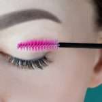 Closed eye with long eyelashes, black eyeliner, perfect skin eyebrow of unrecognizable young woman