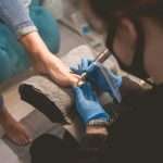 Pedicure master uses nail file drill for preparing nails for pedicure